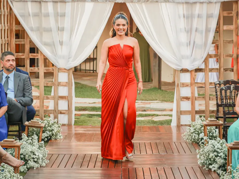 Marina Moura de vestido vermelho caminhando por um cerimonial